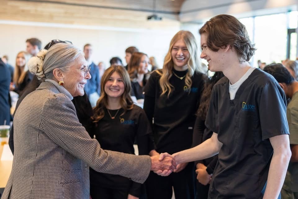 Alice Walton shaking student's hand