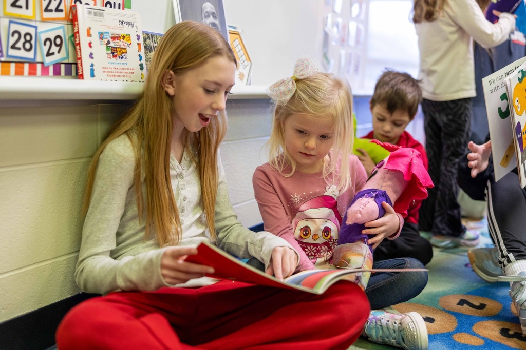 Sixth graders and pre-k students working on a sewing project together