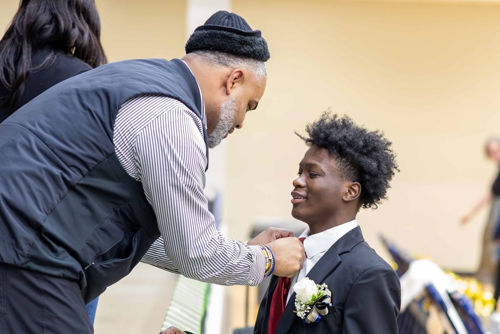 A day adjusting his son's tie before he begins his Color's Day court duties