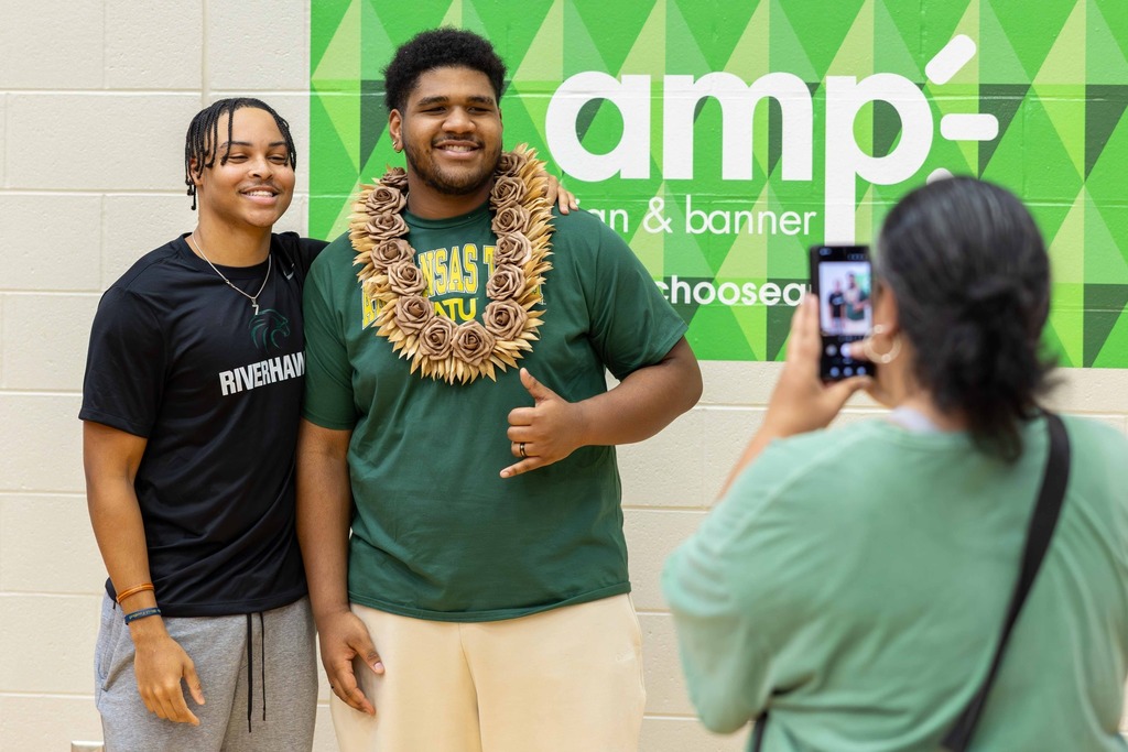 Student-athlete posing for a picture with his family