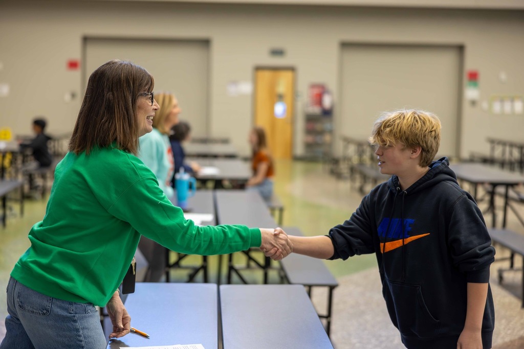 Student and teacher shaking hands
