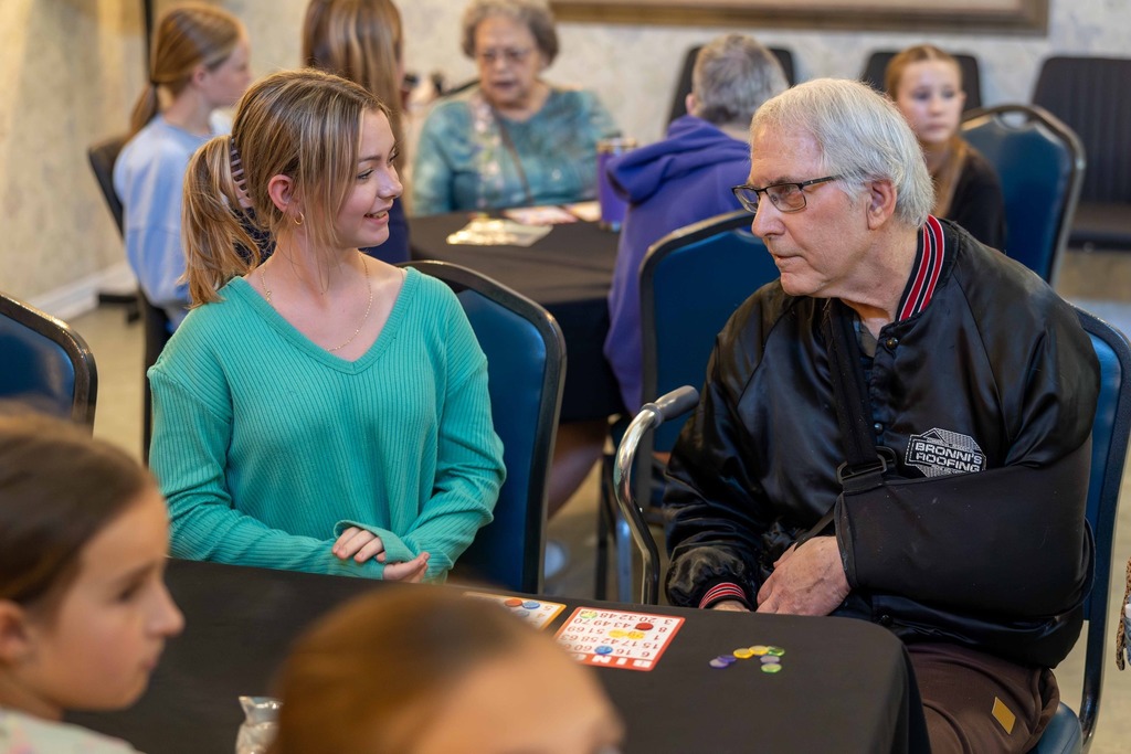 Student smiling at a resident of a local senior living center