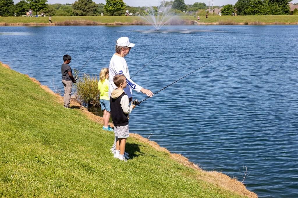 Student fishing with the help of an older adult