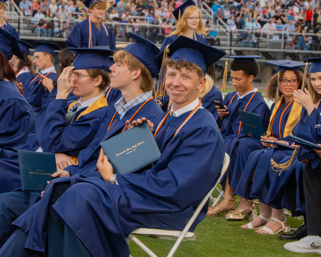 Bentonville West High Senior Holding His Diploma and Smiling