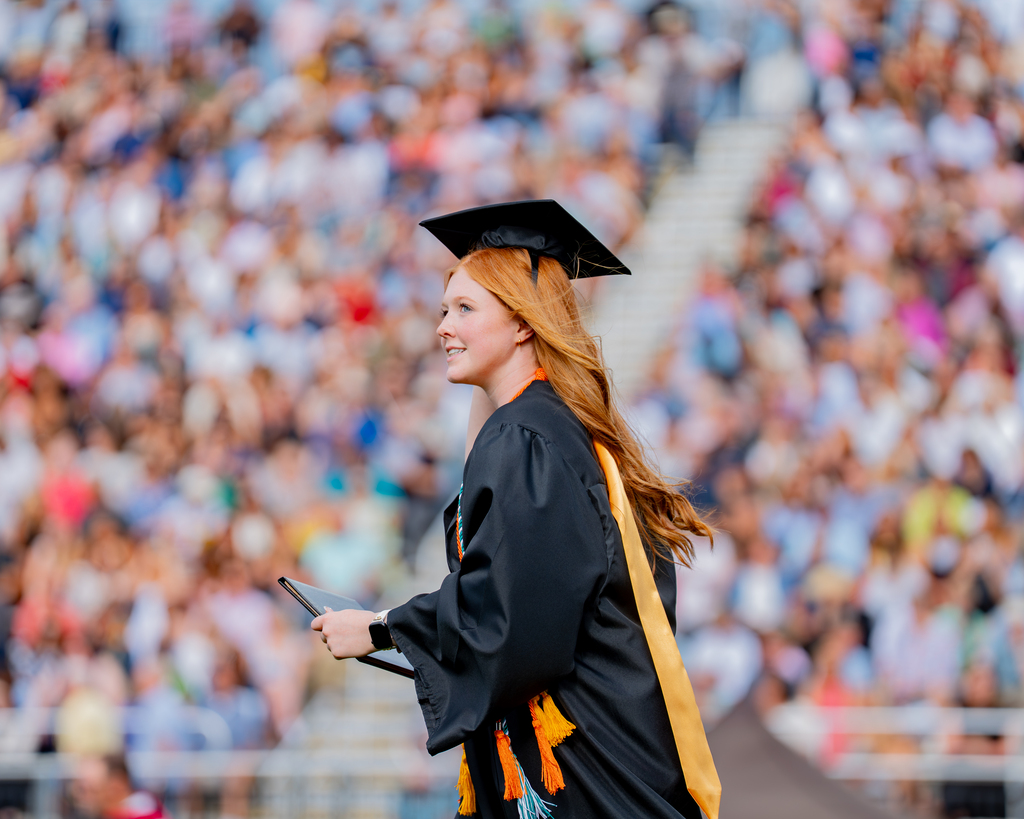 Bentonville High Senior Holding her Diploma and Looking into the Crowd
