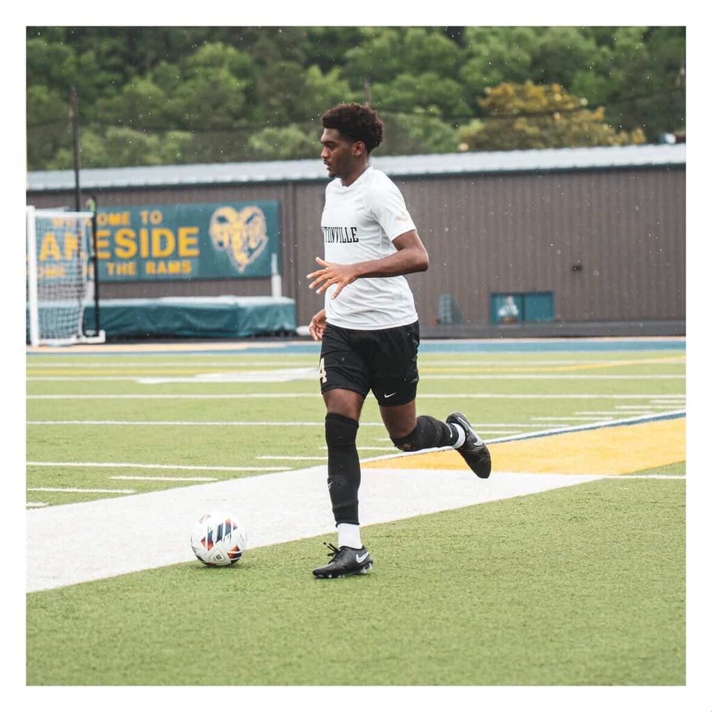 High School Soccer Player Running Down the Pitch