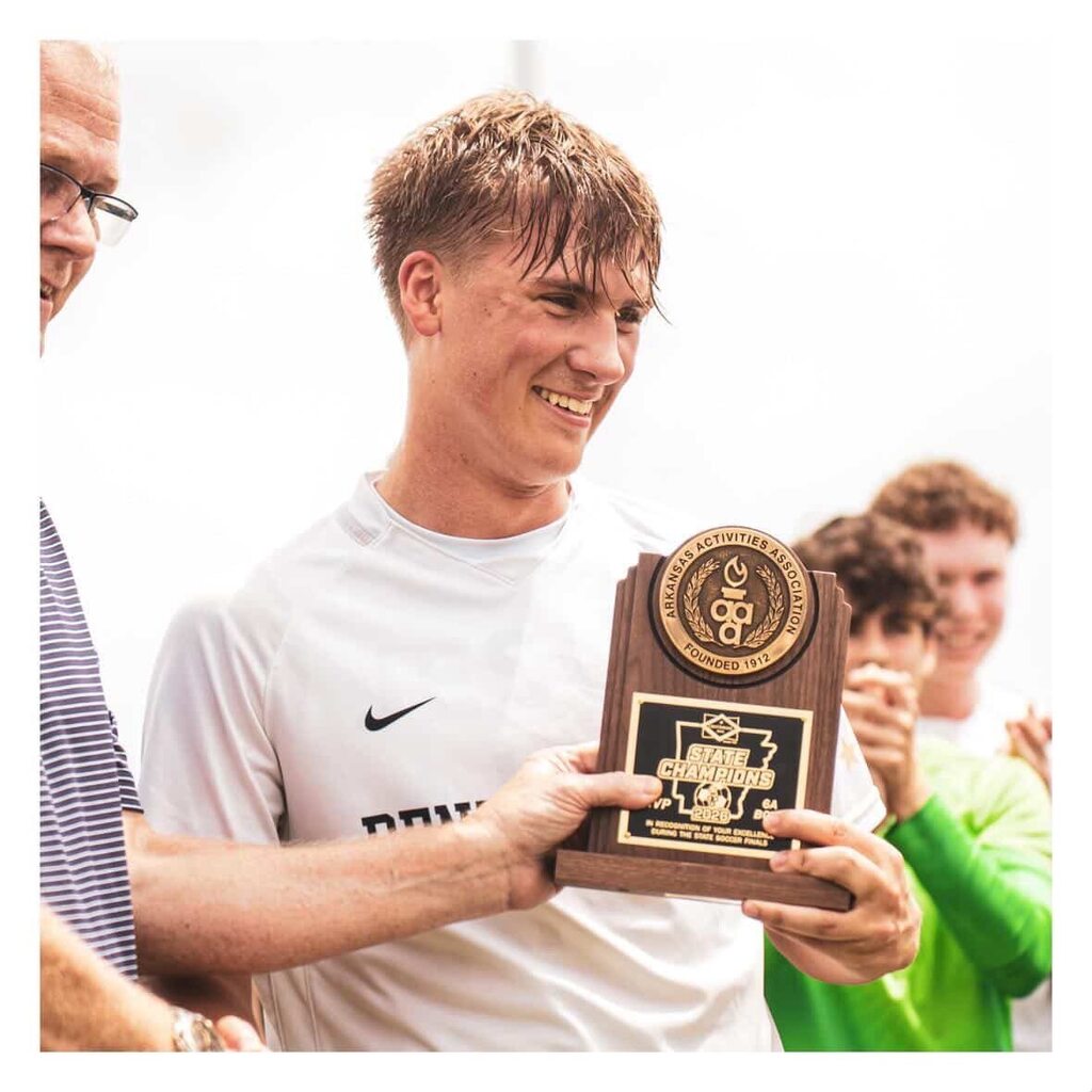 Young soccer player holding MVP plaque