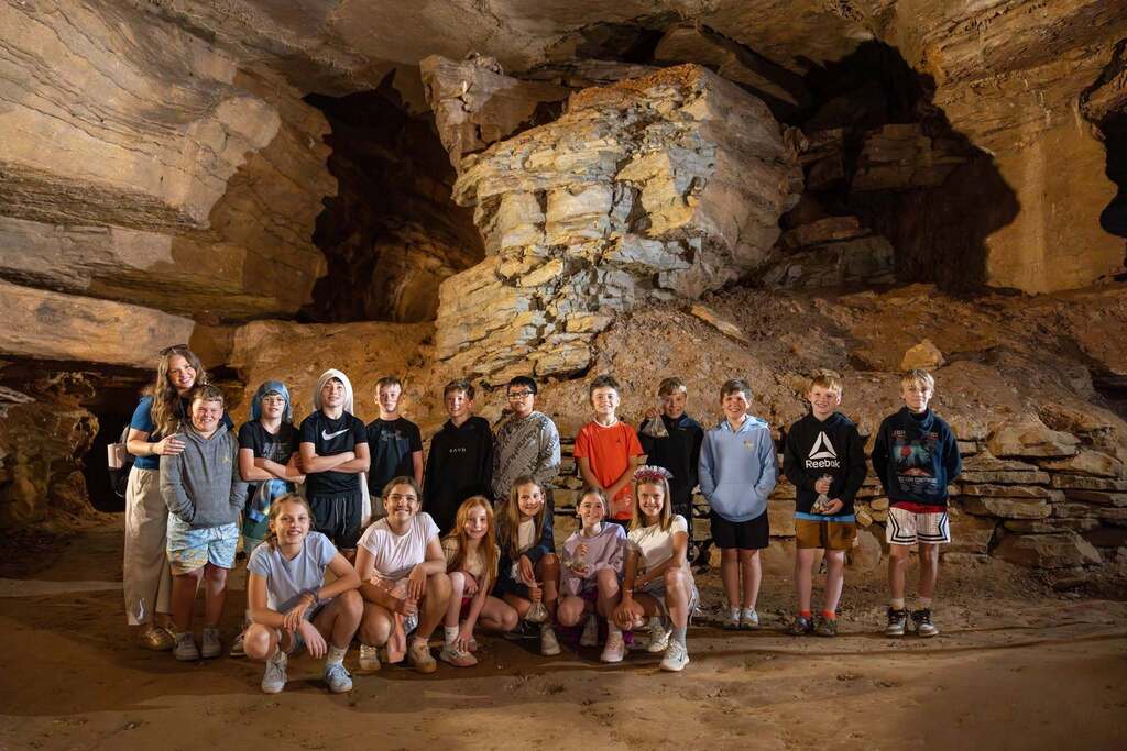 Group of students posing for a photo in a cave