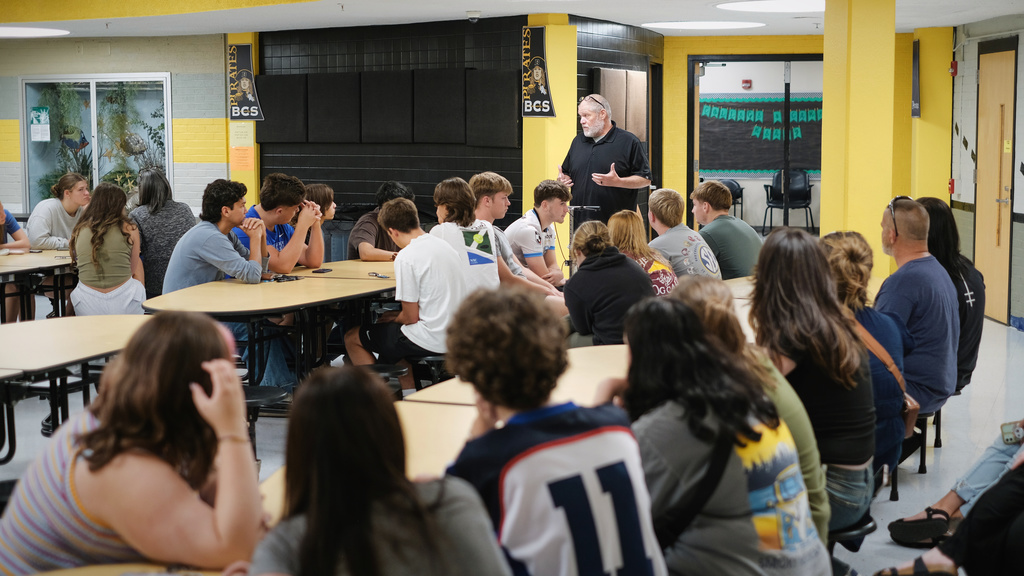 Assistant Principal speaks to students in cafeteria.