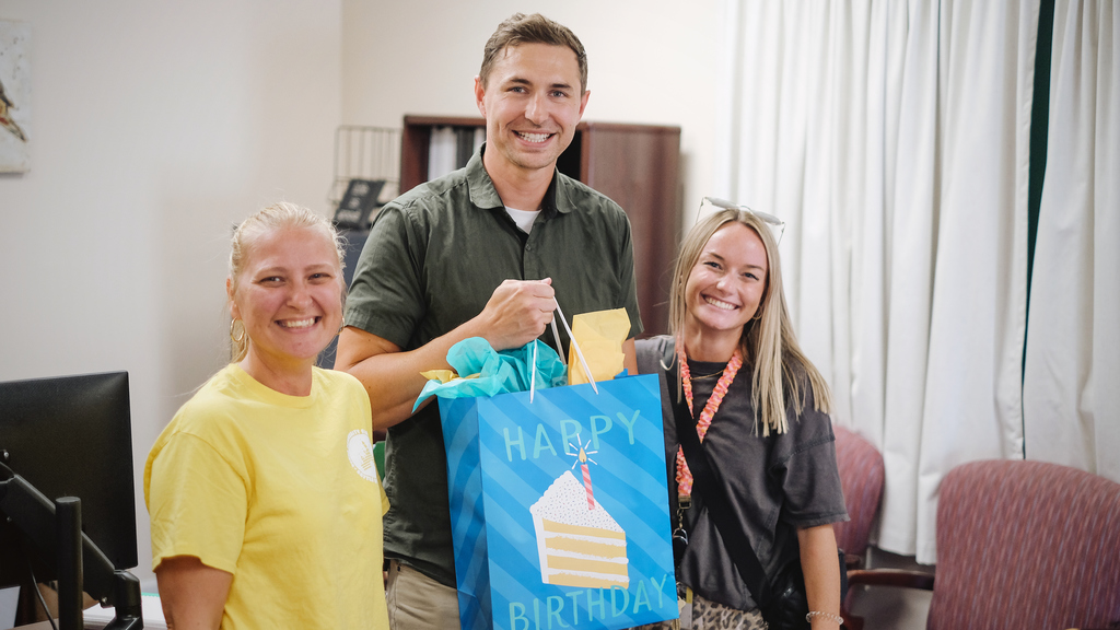 School Superintendent is presented with a birthday present from school staff.