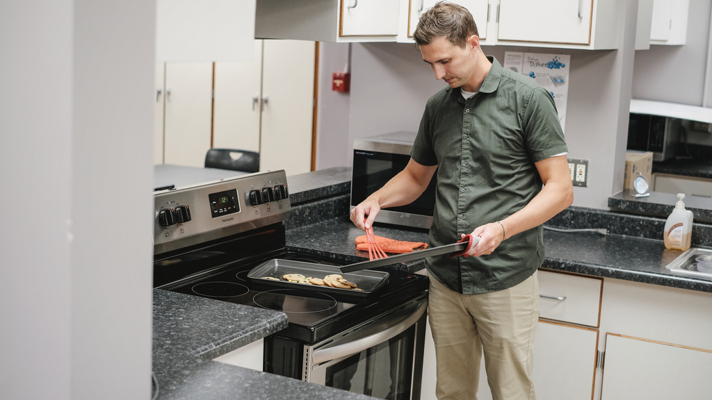 Superintendent baking cookies for school staff.