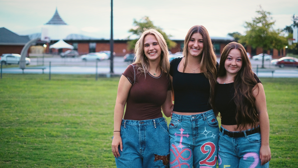 Seniors pose for a photo in front of their school