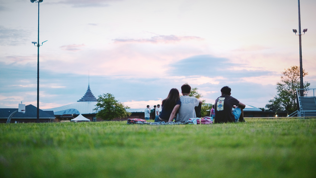 Seniors sit and watch the sunrise behind their school, from the football field.