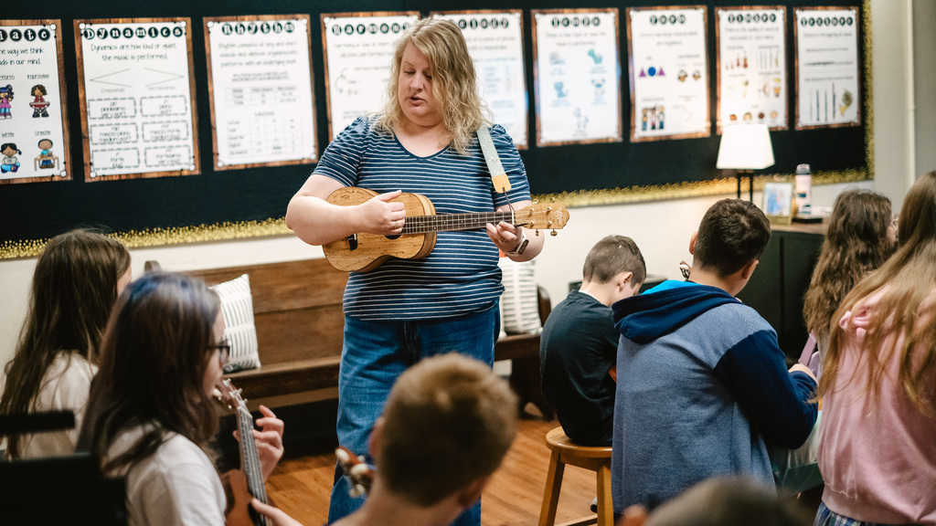 Teacher demonstrates ukulele technique
