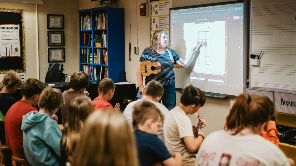 Music Teacher instructs students from front of music room
