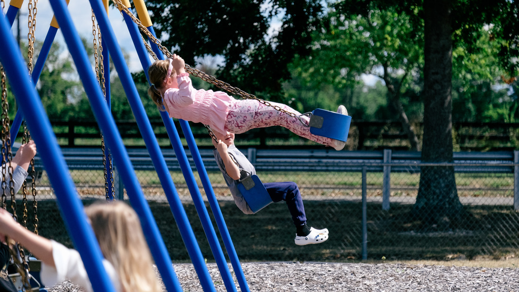 Elementary student plays on swing set