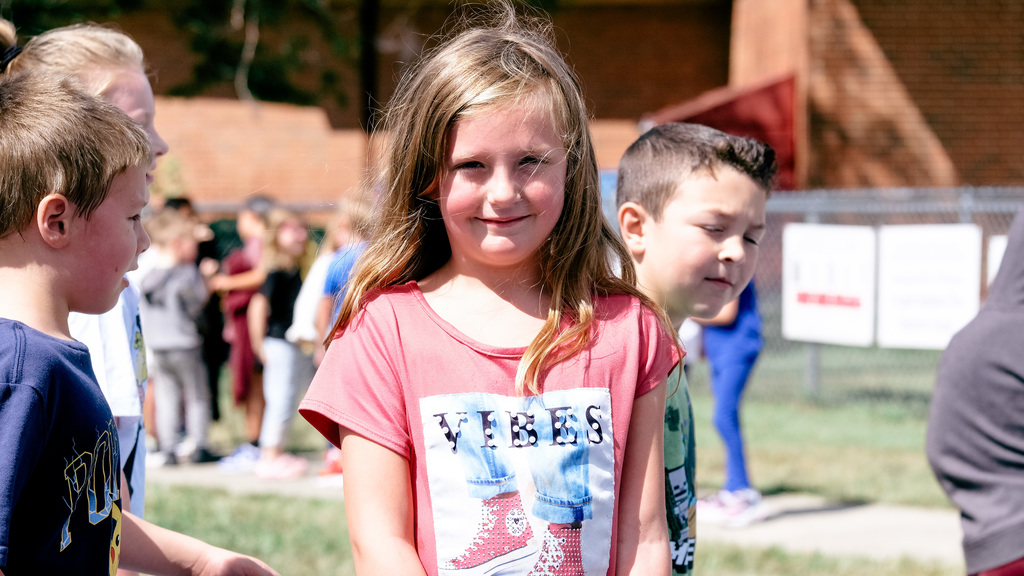 Elementary student poses for photo on playground