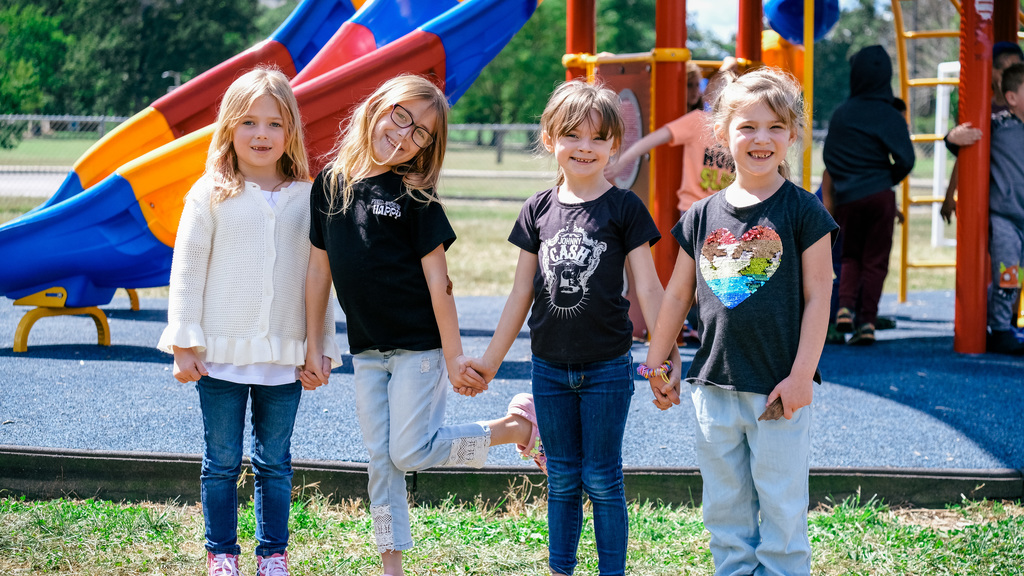 Elementary students pose for a photo on the playground