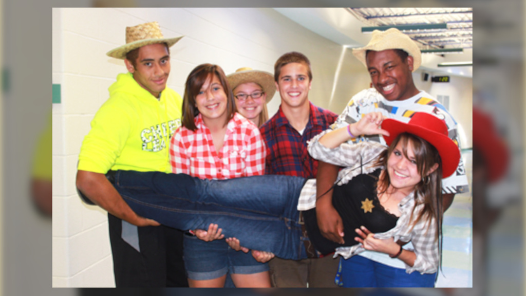 Students dressed in western garb pose for a photo