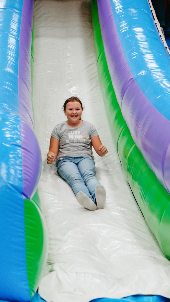 Elementary student slides down an inflatable slide