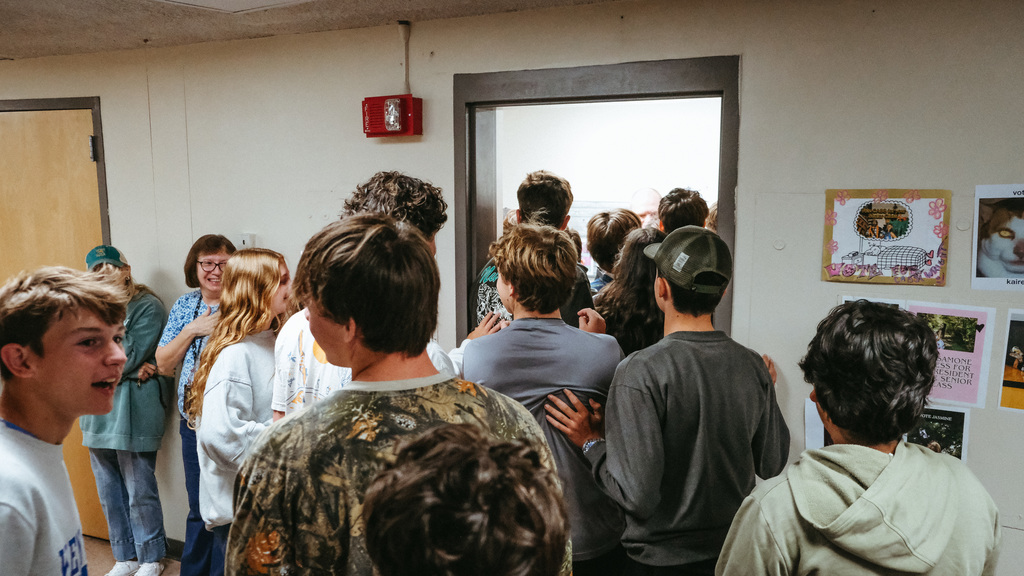 High school students crowd around outside an office