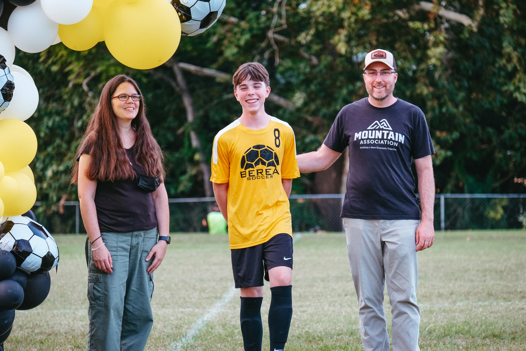 8th grader poses for photo with parents