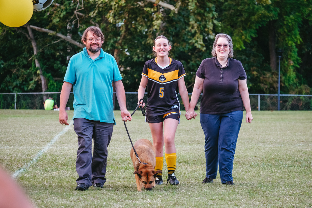 8th grader poses for photo with family