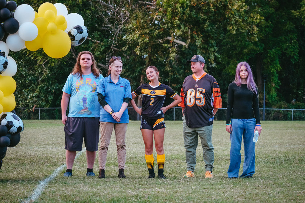 8th grader poses for photo with family