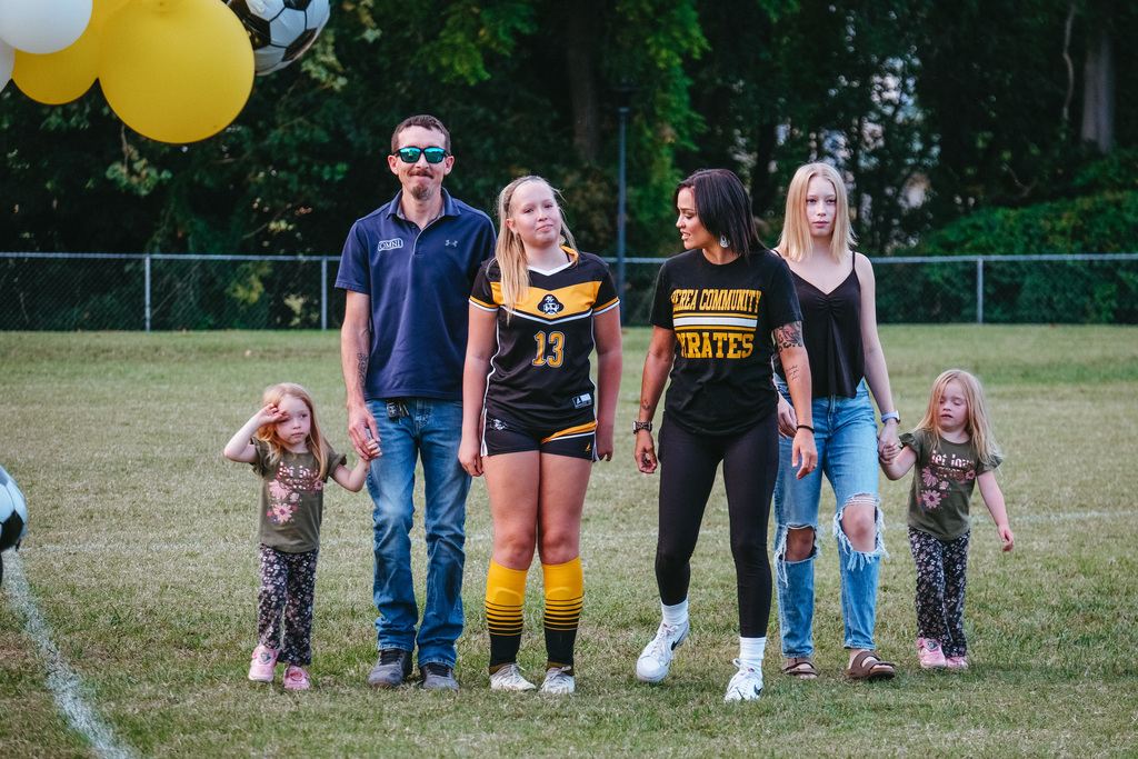 8th grader poses for photo with family