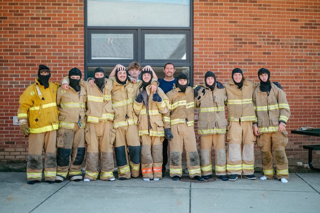 Students pose in firefighter gear