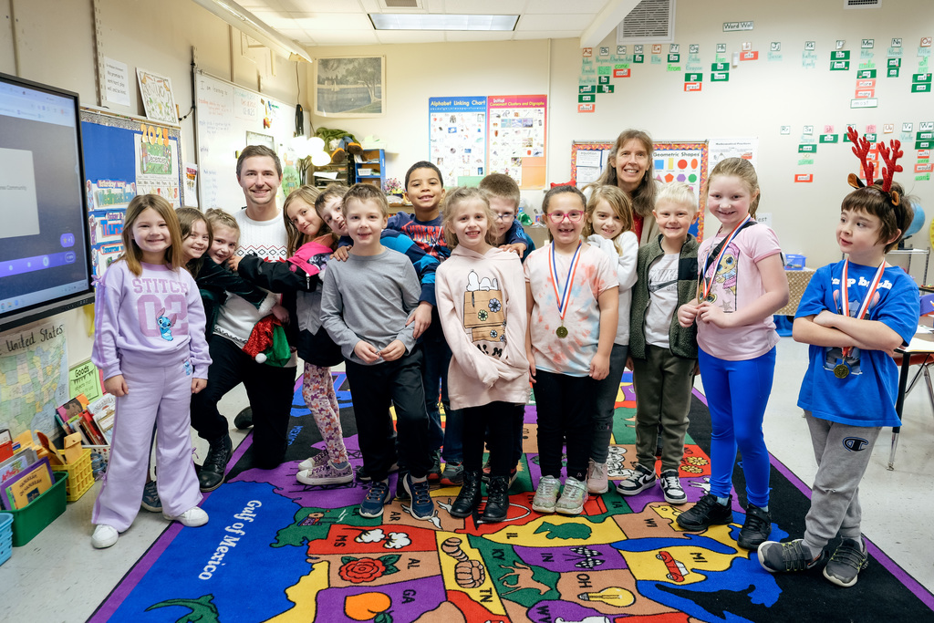 Dr. Neaves poses for a photo with Ms. Satterthwaite's 1st grade class.