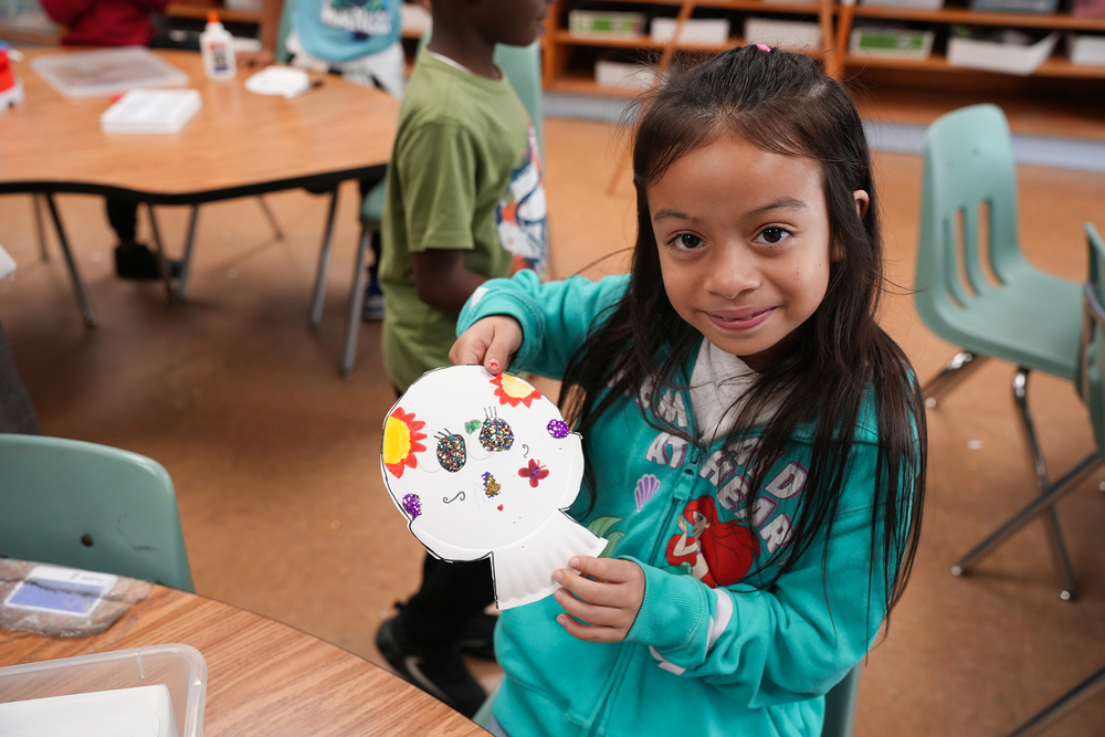 second grader holding up project