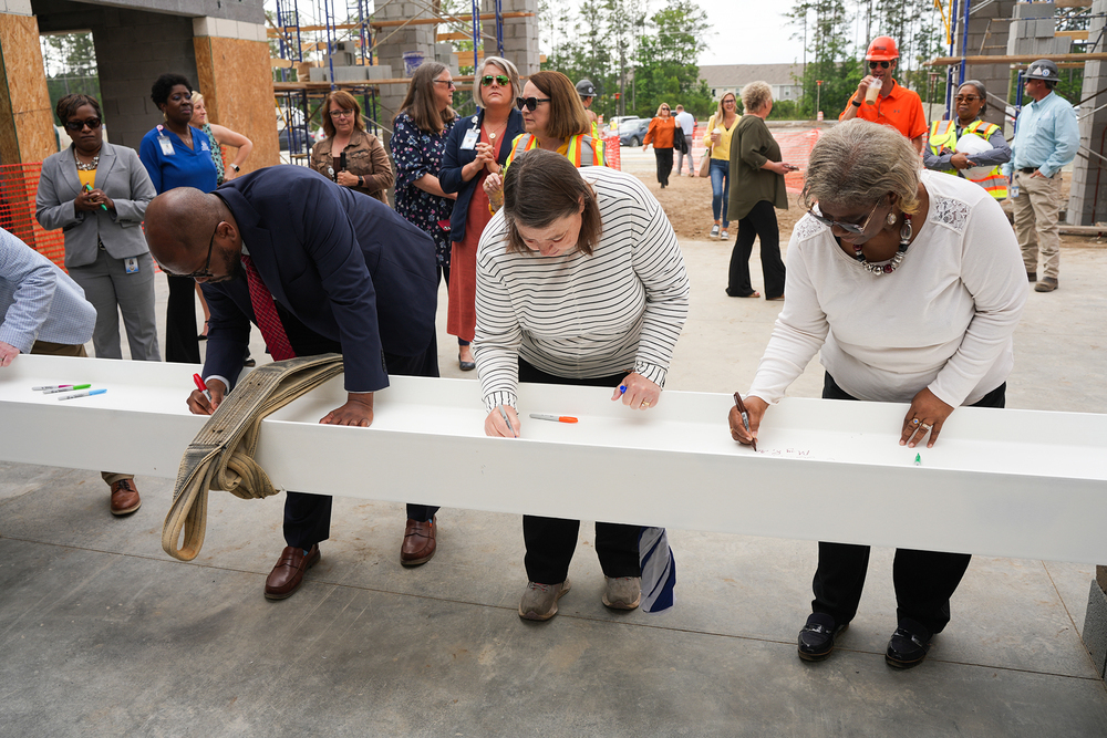 Superintendent Dixon and board members signing topping off beam