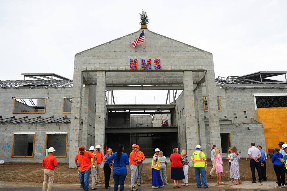 attendees standing in front of HMS under construction 