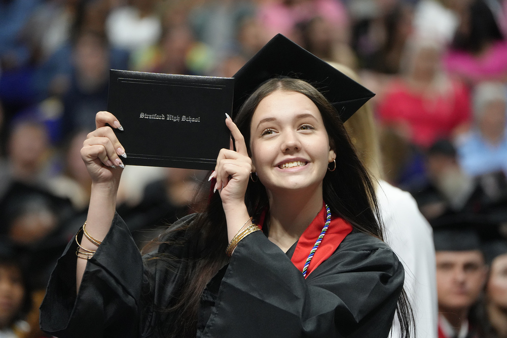 girl holding up diploma