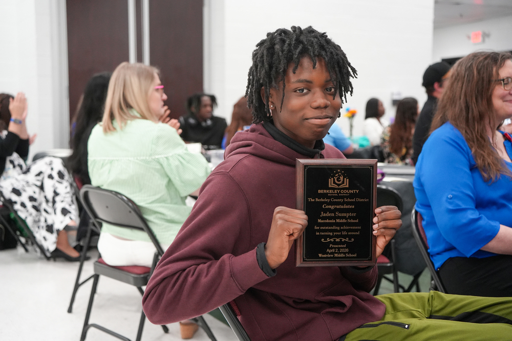child holding up plaque