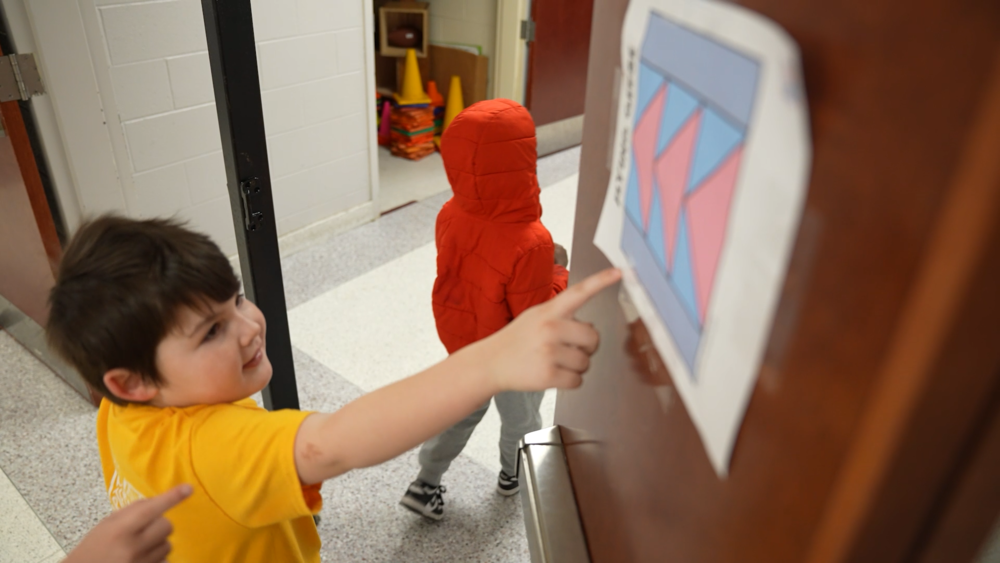 Student points at quilt sign