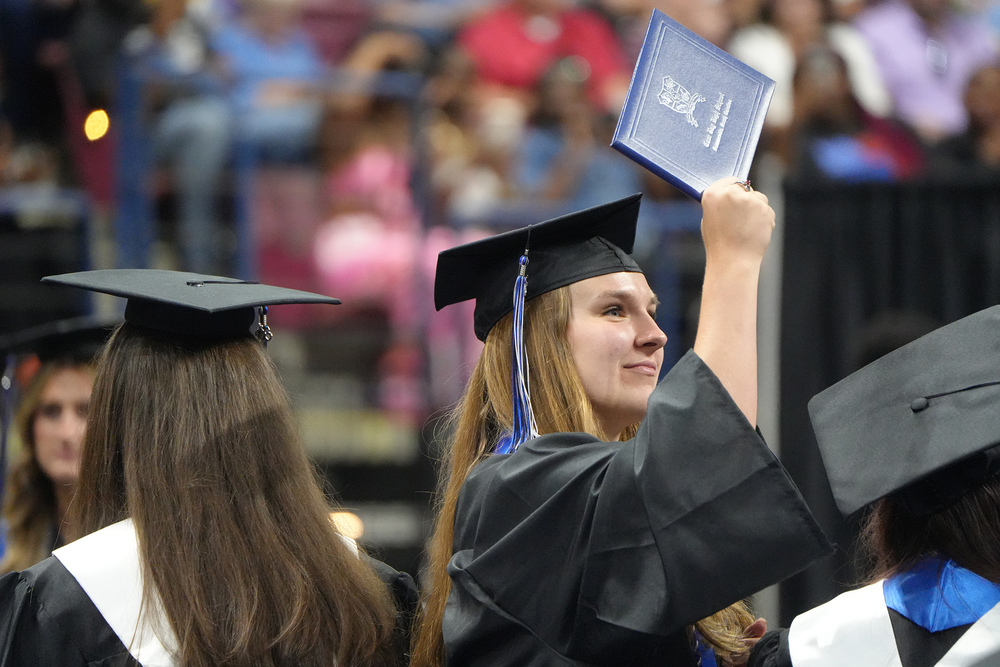 girl holding up diploma