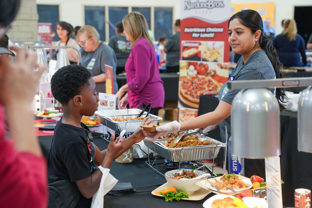 child getting food from vendor