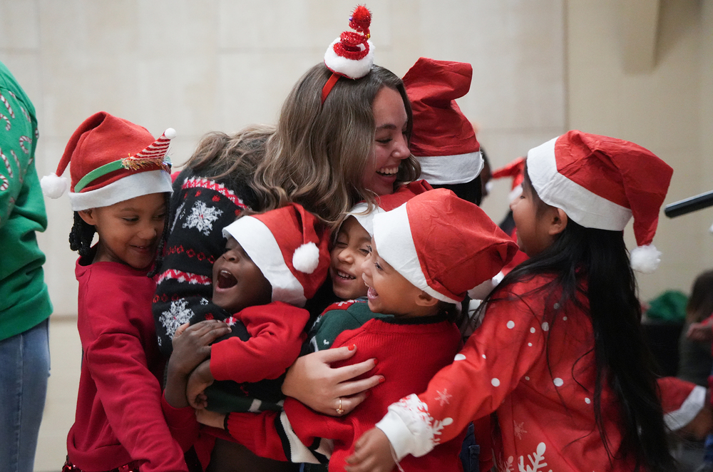 students hugging teacher