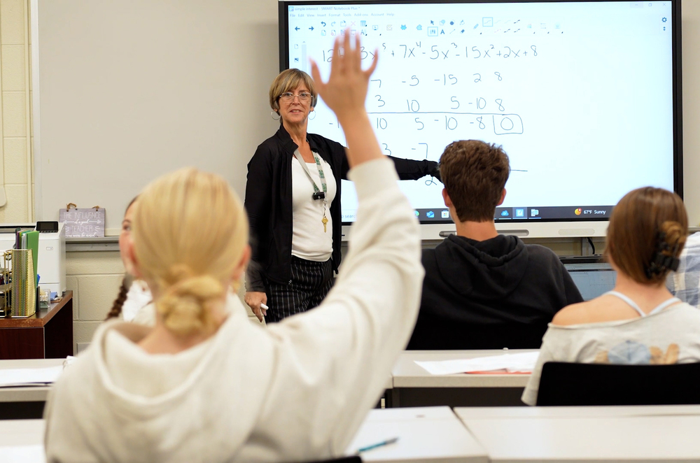 student raising hand in classroom