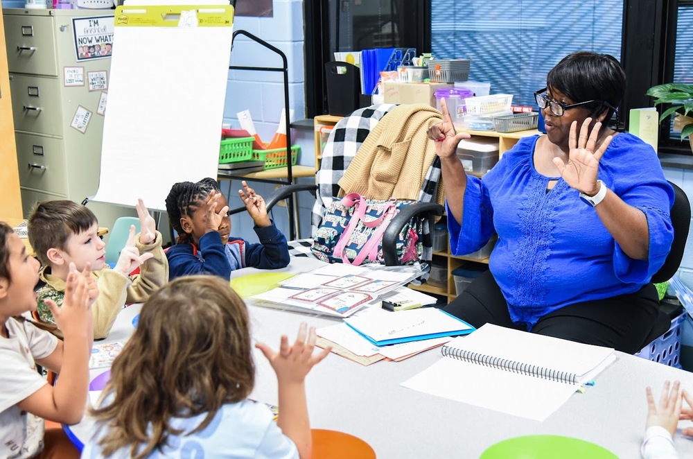 Teacher with elementary students counting with their fingers