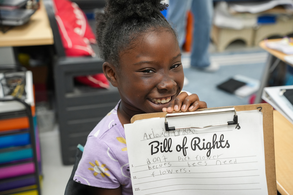 girl holding up worksheet that reads "bill of rights"