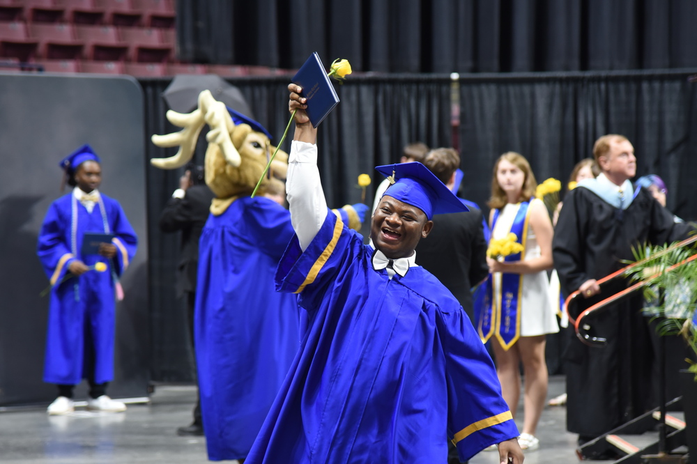 Berkleey high graduate holding up diploma and cheering