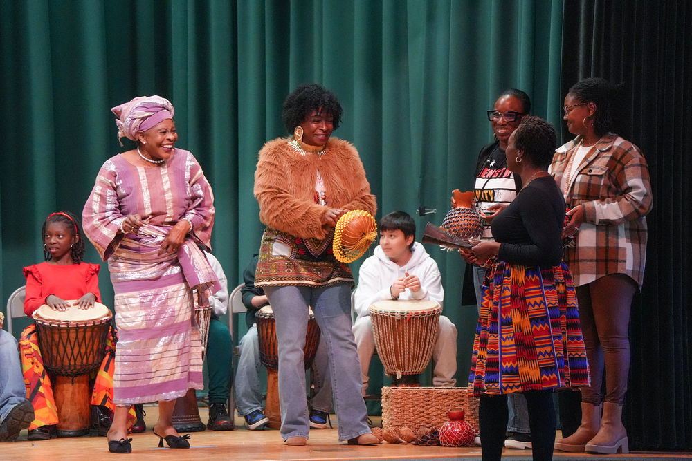 students and staff on stage