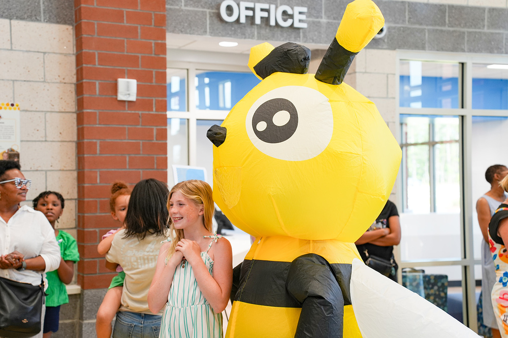 student standing with blow-up bee