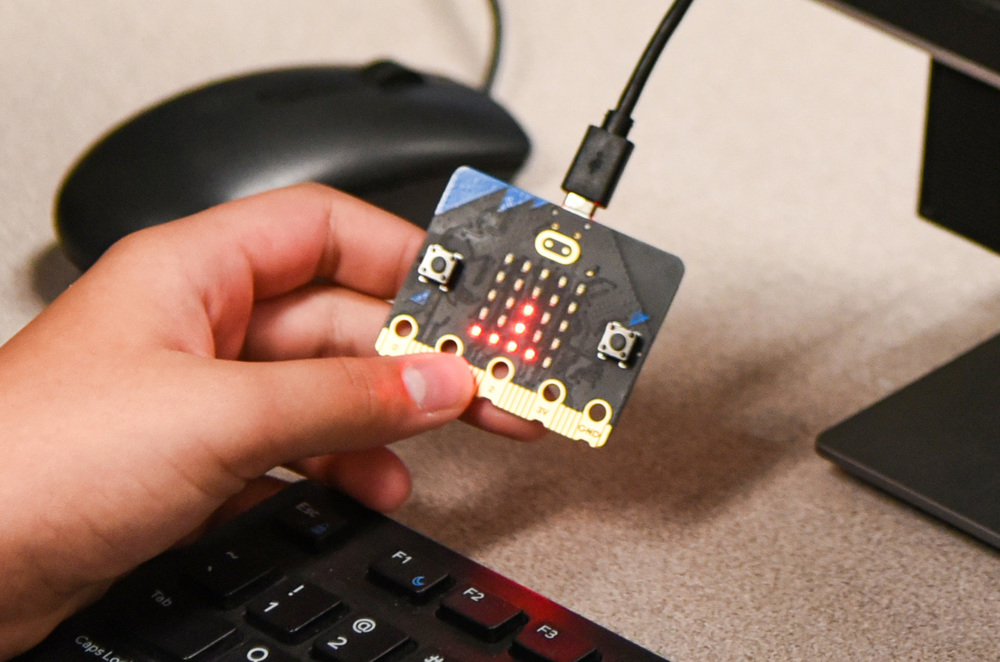 students hand with computer chip