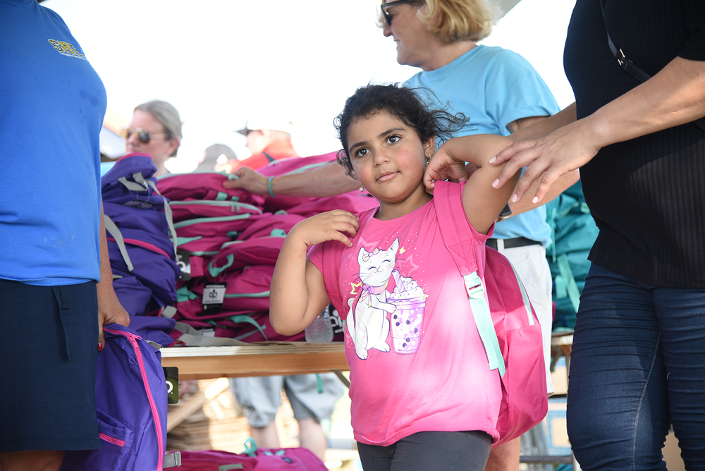 girl putting on backpack