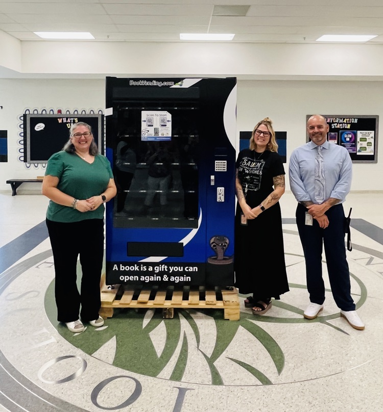 staff standing in front of new book vending machine