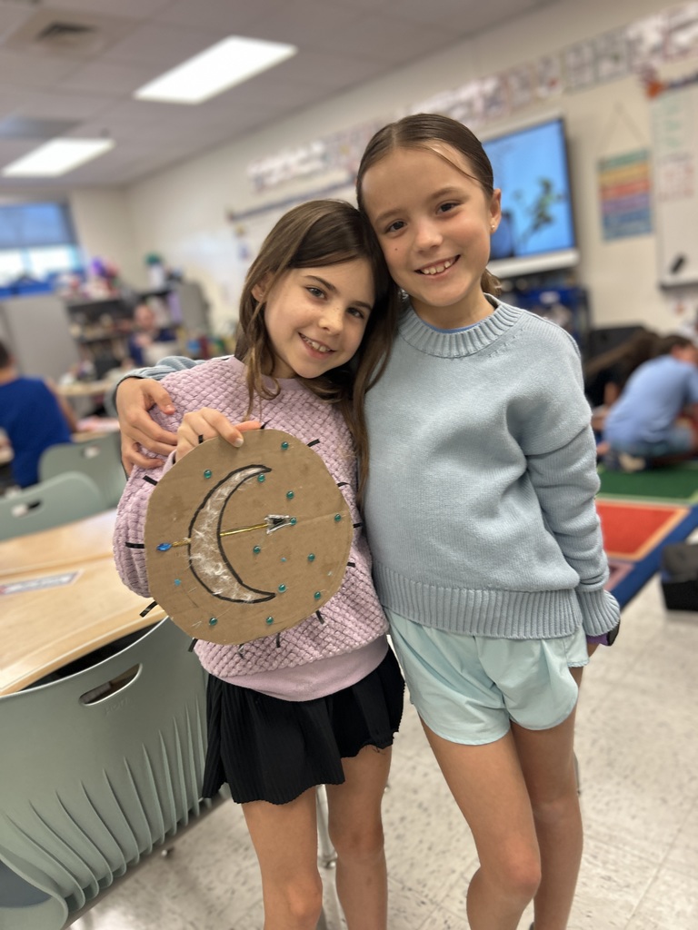 The girls show off their cabin's shield.